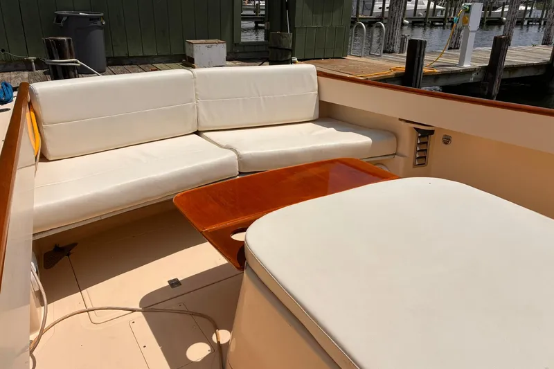 Slide: The Image of Hinckley Picnic Boat 36 Classic 1995 interior with white seating and wooden table. - 35