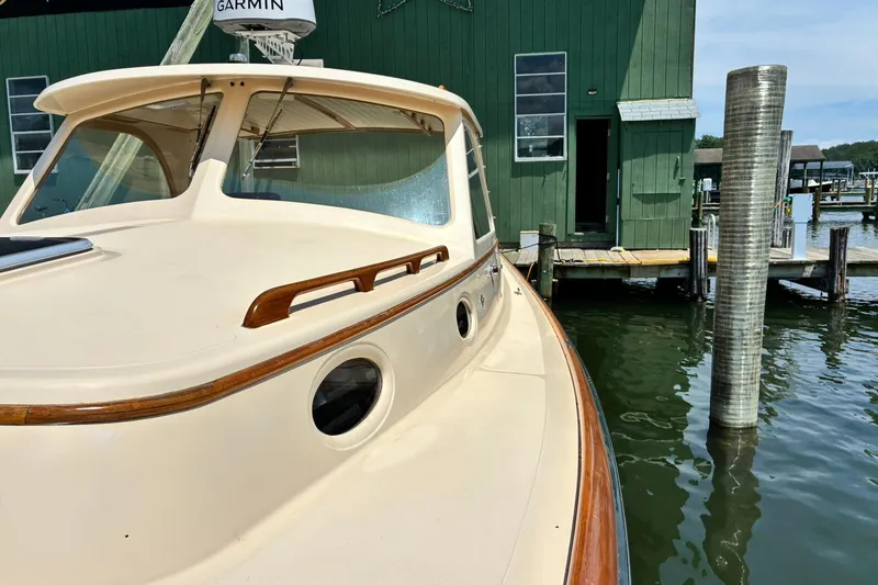 Slide: The Image of Hinckley Picnic Boat 36 Classic, 1995, docked near a green boathouse. - 36