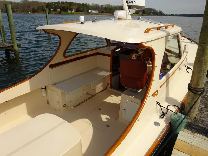 Slide: The Image of 1995 Hinckley Picnic Boat Classic docked, showcasing elegant design and spacious seating area. - 4