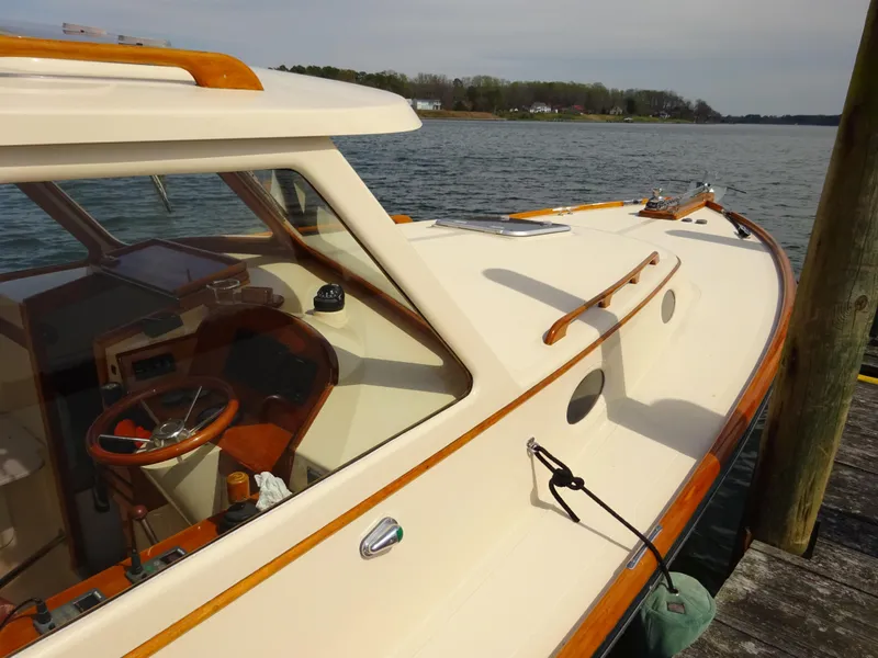 Slide: The Image of 1995 Hinckley Picnic Boat Classic docked, showcasing elegant design and wooden accents. - 5