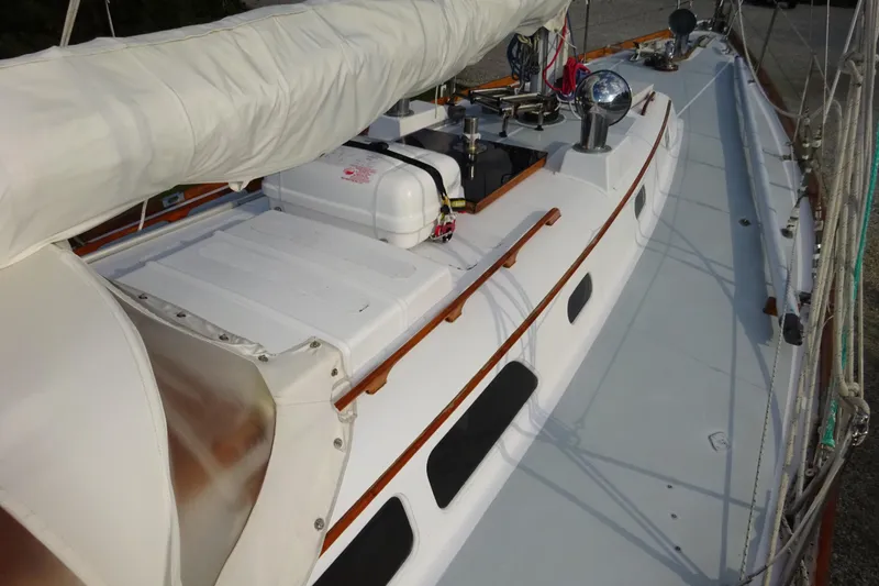 Slide: The Image of 1970 Hinckley Bermuda 40 Custom sailboat deck with white cover and wooden accents. - 14