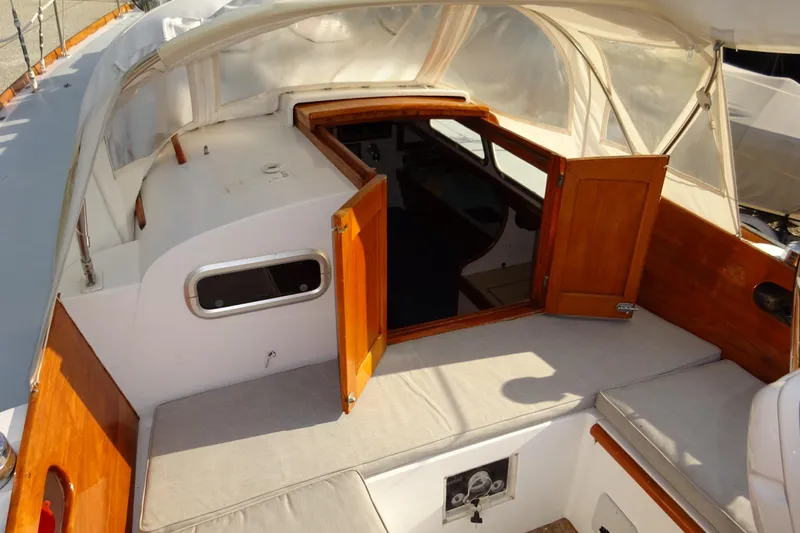 Slide: The Image of 1970 Hinckley Bermuda 40 Custom sailboat cockpit with open wooden doors and cushioned seating. - 42