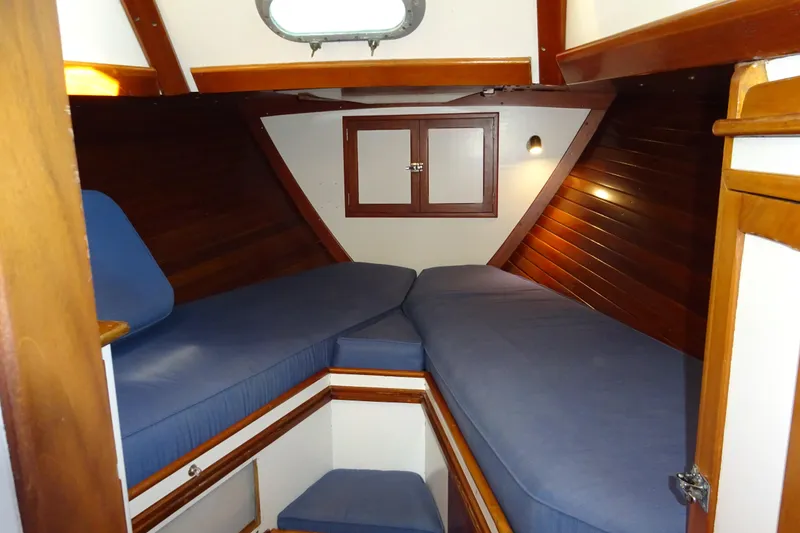 Slide: The Image of Interior cabin of 1970 Hinckley Bermuda 40 Custom sailboat with blue cushions and wooden finish. - 56