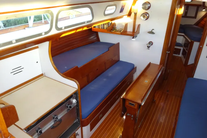 Slide: The Image of Interior of 1970 Hinckley Bermuda 40 Custom sailboat with wooden furnishings and blue cushions. - 45