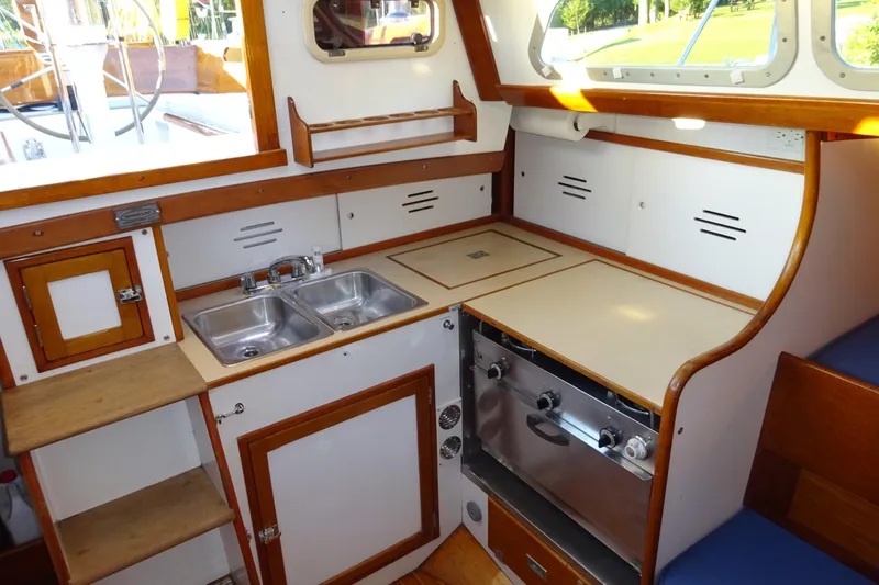 Slide: The Image of 1970 Hinckley Bermuda 40 Custom yacht interior with compact kitchen, dual sinks, and wooden cabinetry. - 54