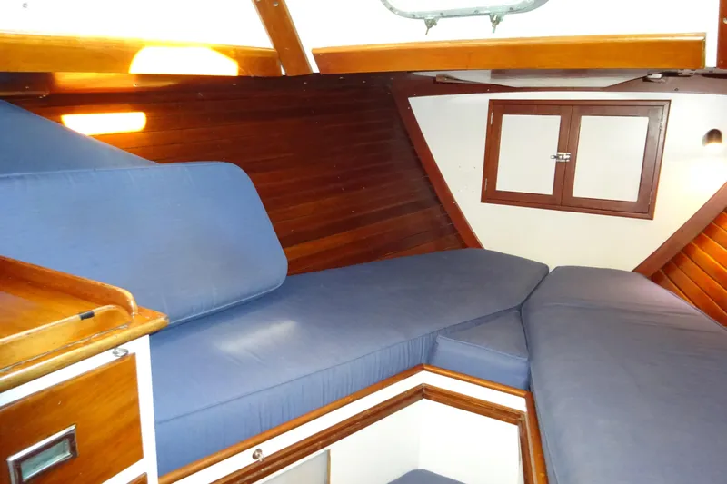 Slide: The Image of 1970 Hinckley Bermuda 40 Custom yacht interior with blue cushions and wooden cabinetry. - 57