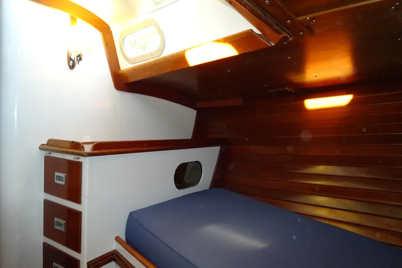 Slide: The Image of Interior cabin of 1970 Hinckley Bermuda 40 Custom sailboat with wooden paneling and blue cushion. - 58