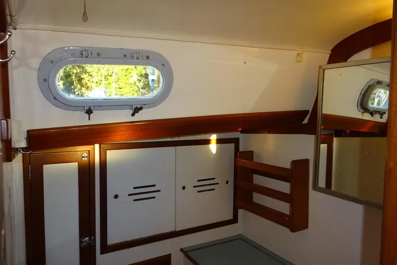 Slide: The Image of 1970 Hinckley Bermuda 40 Custom yacht interior with wooden accents and porthole window. - 62