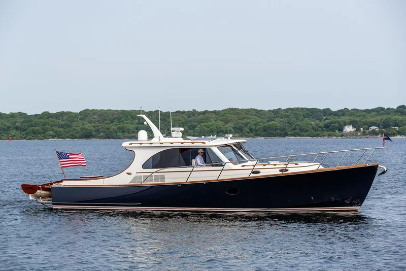 Slide: The Image of 2014 Hinckley Talaria 43 yacht cruising on calm waters with American flag. - 11