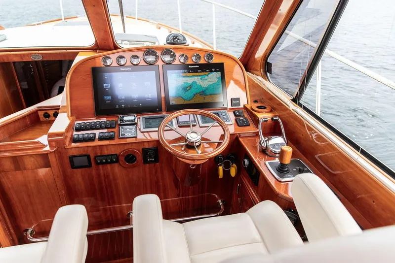Slide: The Image of Helm of 2014 Hinckley Talaria 43 yacht with wooden dashboard and modern navigation screens. - 13