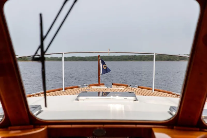Slide: The Image of 2014 Hinckley Talaria 43 yacht deck view with flag on calm water. - 28