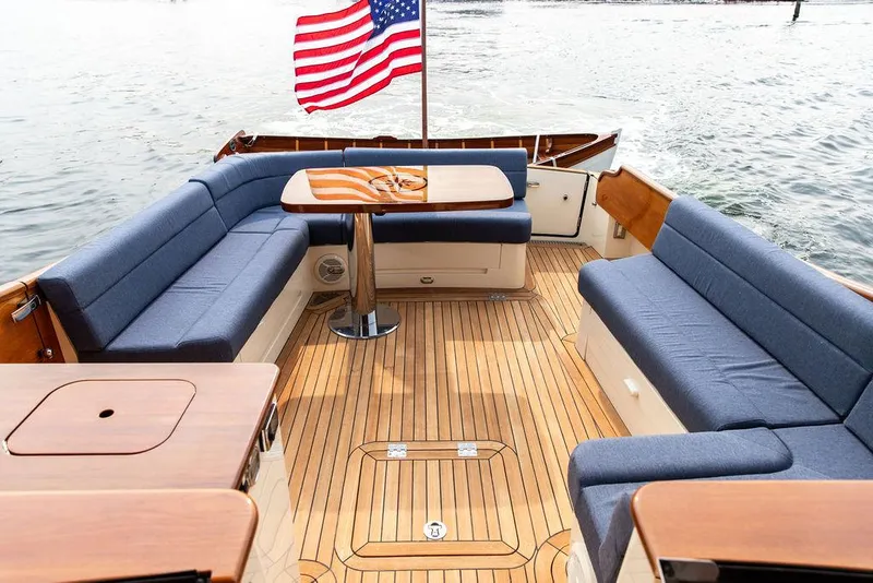 Slide: The Image of 2014 Hinckley Talaria 43 yacht with teak deck and blue seating, American flag waving. - 31