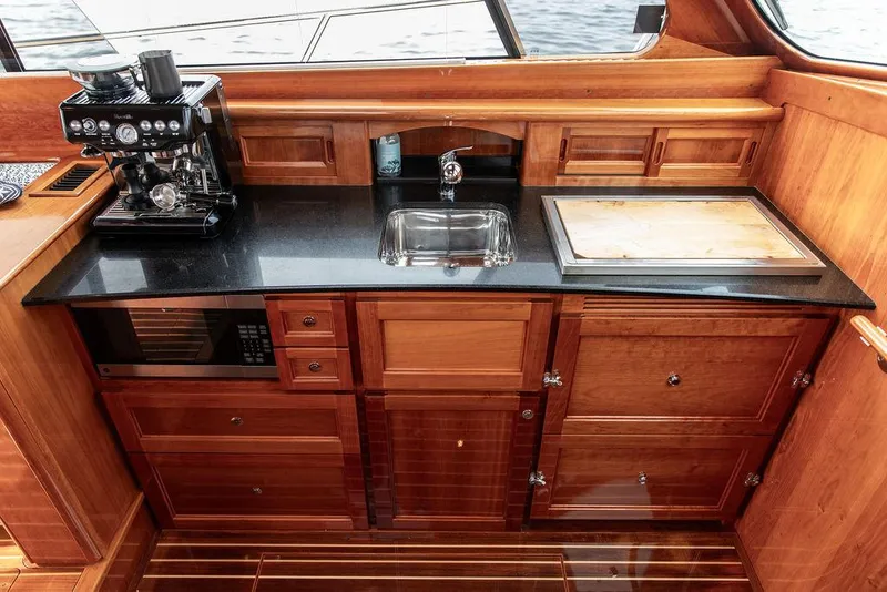 Slide: The Image of Luxurious galley in 2014 Hinckley Talaria 43 yacht with wood cabinetry and modern appliances. - 35