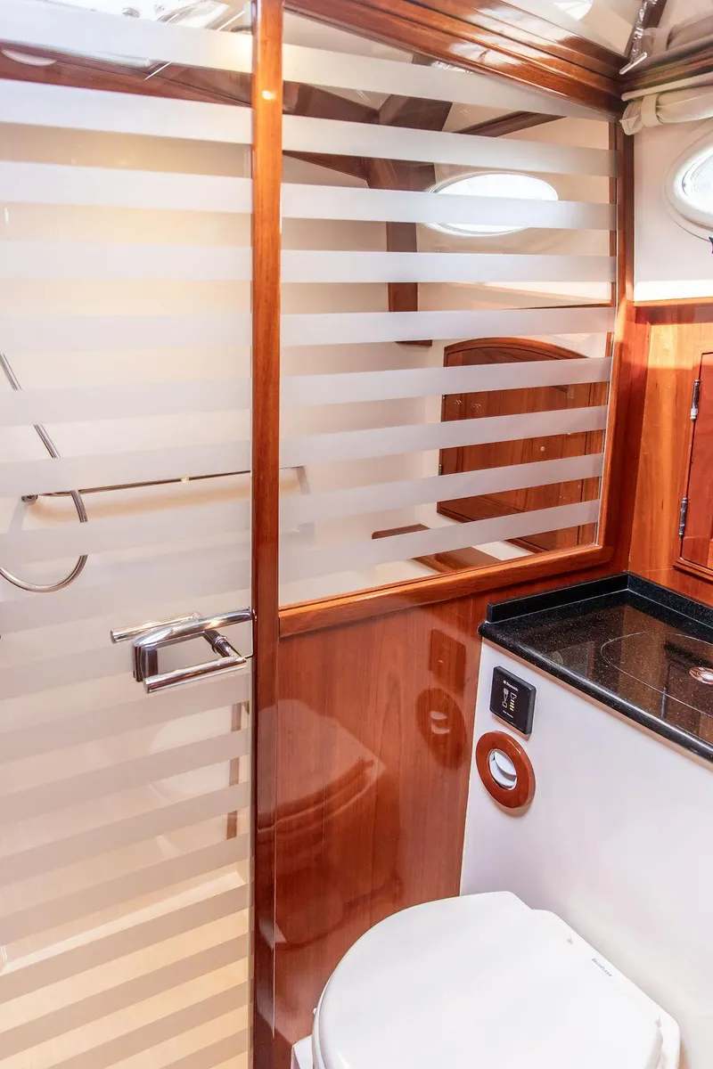 Slide: The Image of Luxury bathroom in 2014 Hinckley Talaria 43 yacht with modern fixtures and wood accents. - 42