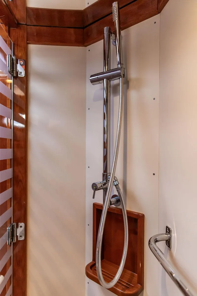 Slide: The Image of Shower area in 2014 Hinckley Talaria 43 yacht with chrome fixtures and wooden accents. - 44
