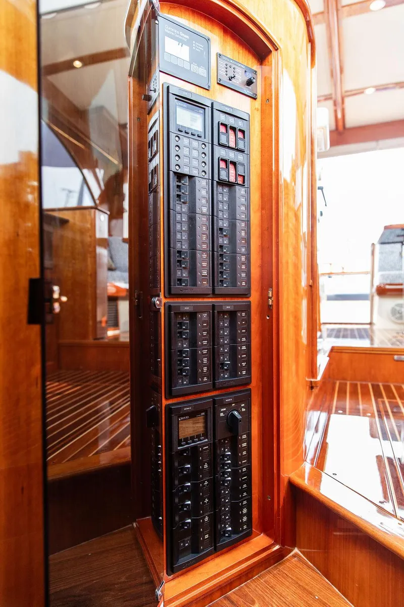 Slide: The Image of Electrical panel inside 2014 Hinckley Talaria 43 yacht, featuring polished wood finish. - 48