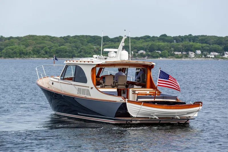 Slide: The Image of 2014 Hinckley Talaria 43 yacht cruising on a calm lake with lush green shoreline. - 5