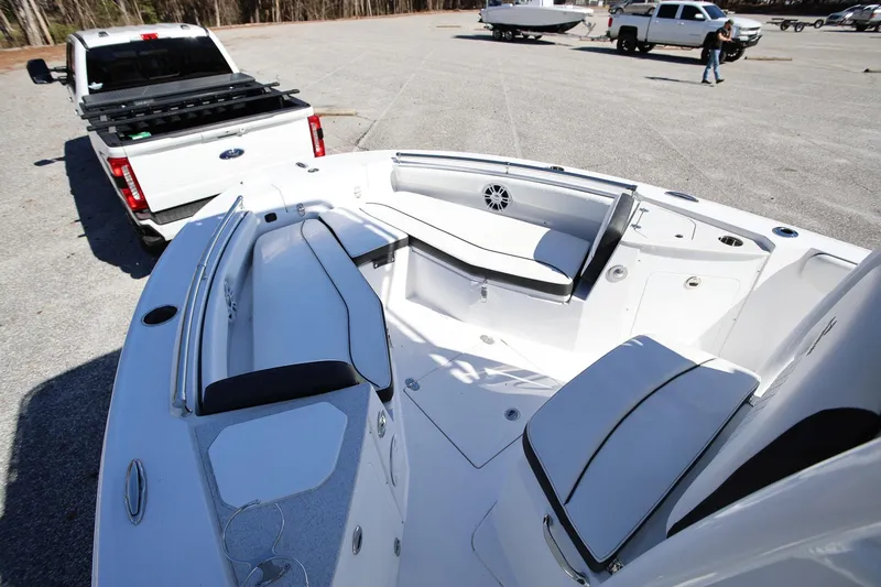 Slide: The Image of 2025 Stingray 216 CC boat interior with seating, parked near a white pickup truck. - 13