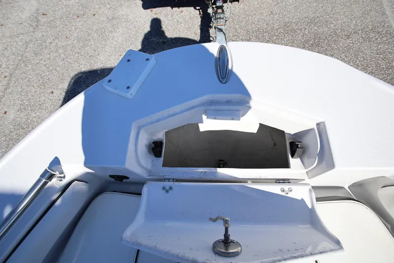 Slide: The Image of 2025 Stingray 216 CC boat bow storage compartment, open and empty, on a sunny day. - 20