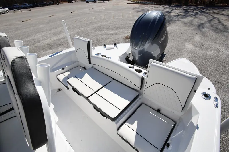 Slide: The Image of 2025 Stingray 216 CC boat interior with Yamaha engine, featuring white seating and cup holders. - 7