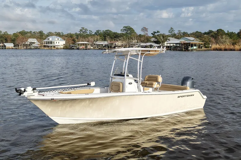 Slide: The Image of 2017 Sportsman Heritage 211 Center Console boat on a calm lake with houses in the background. - 2