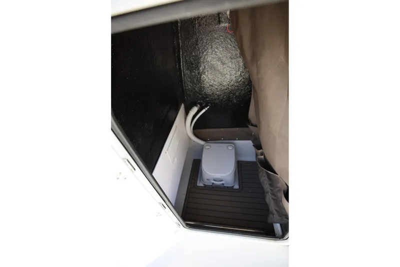 Slide: The Image of 2025 Stingray 216 CC boat interior with compact toilet and storage area. - 15