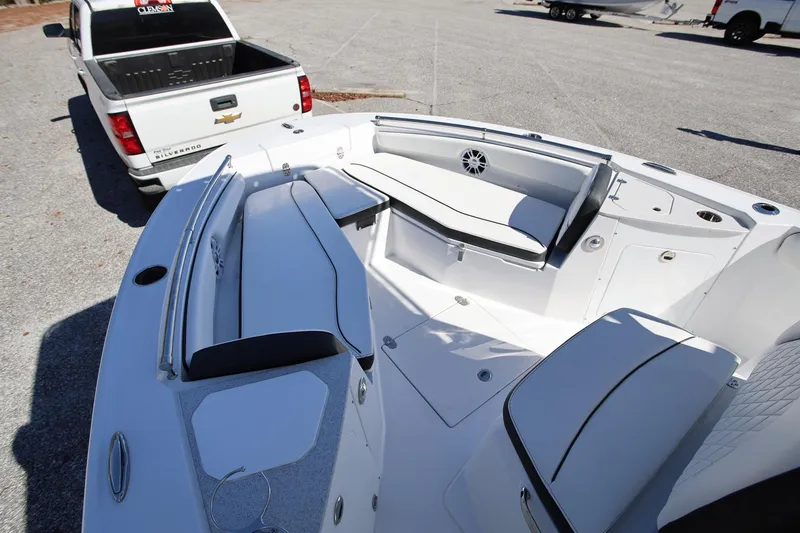 Slide: The Image of 2025 Stingray 216 CC boat interior with white seating, parked near a Chevrolet Silverado truck. - 17
