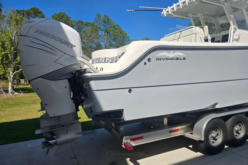 Slide: The Image of 2022 Invincible 33 Catamaran with Mercury Verado outboard engine, parked outdoors. - 13