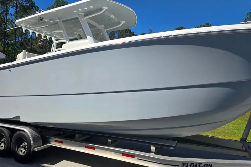 Slide: The Image of 2022 Invincible 33 Catamaran on trailer, parked in driveway near house. - 3