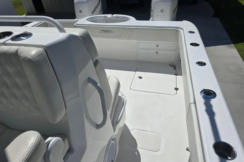 Slide: The Image of 2022 Invincible 33 Catamaran interior with white seating and storage compartments. - 33