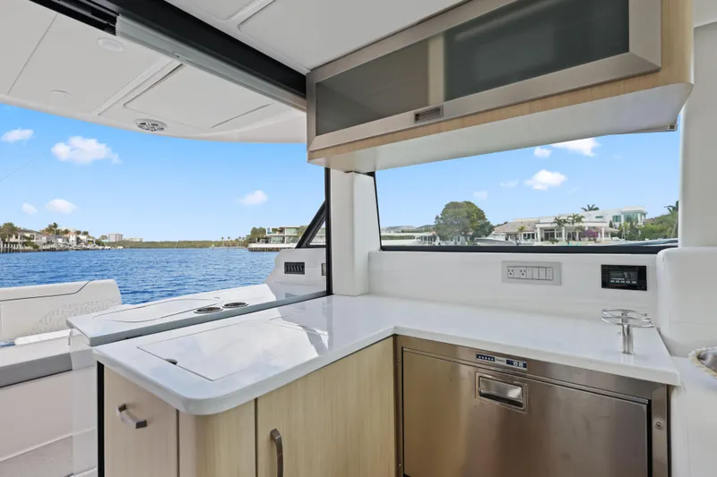 Slide: The Image of 2024 Regal 38 XO yacht interior with modern kitchen and scenic water view. - 12