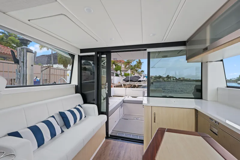 Slide: The Image of 2024 Regal 38 XO yacht interior with modern seating and waterfront view. - 17