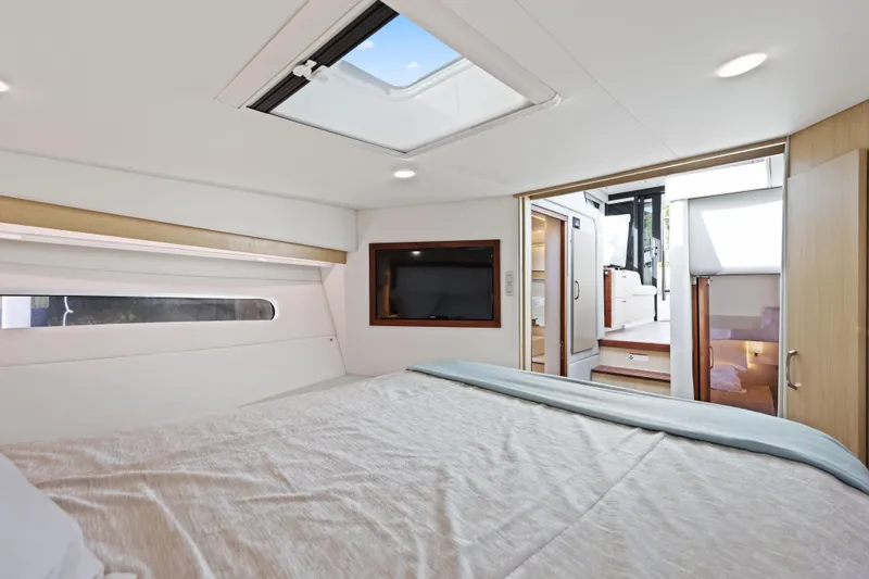 Slide: The Image of Luxurious interior of 2024 Regal 38 XO yacht with modern bedroom and skylight. - 27