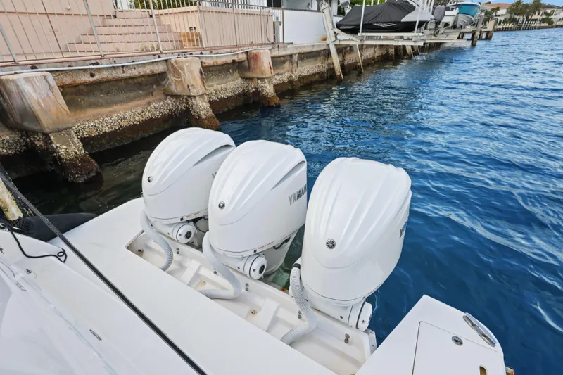 Slide: The Image of 2024 Regal 38 XO boat with triple Yamaha outboard engines docked by the water. - 37