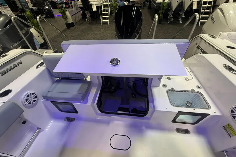 Slide: The Image of 2026 Sportsman Heritage 231 Center Console boat interior with seating and table setup. - 8