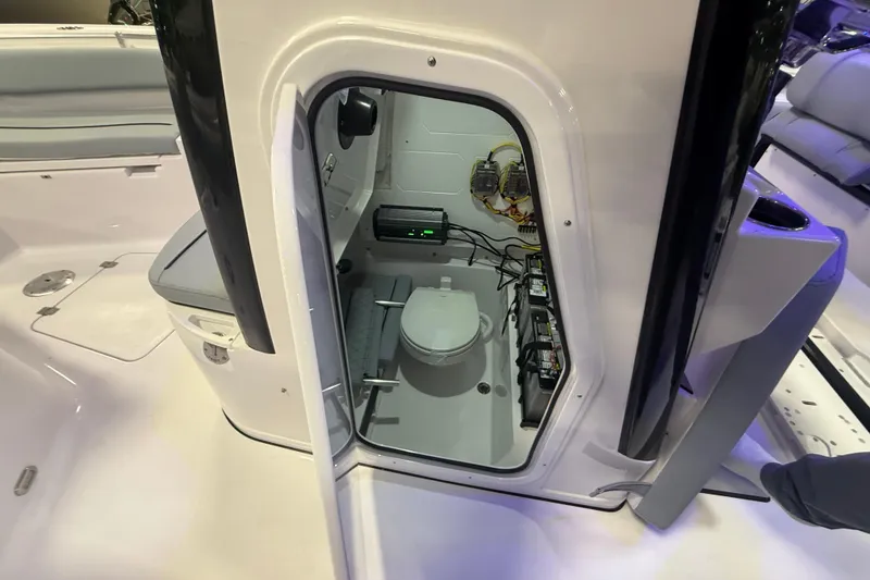 Slide: The Image of 2026 Sportsman Heritage 231 Center Console boat interior with compact marine toilet. - 9