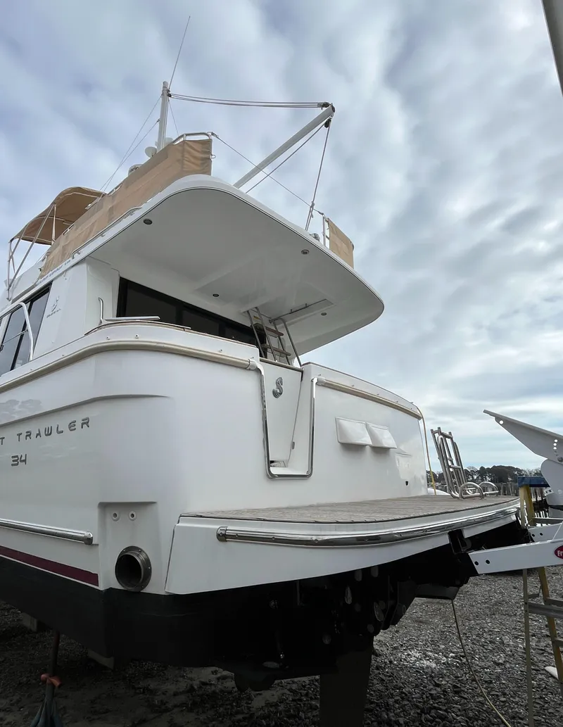 Slide: The Image of 2013 Beneteau Swift Trawler 34, docked, showcasing rear view and upper deck. - 10