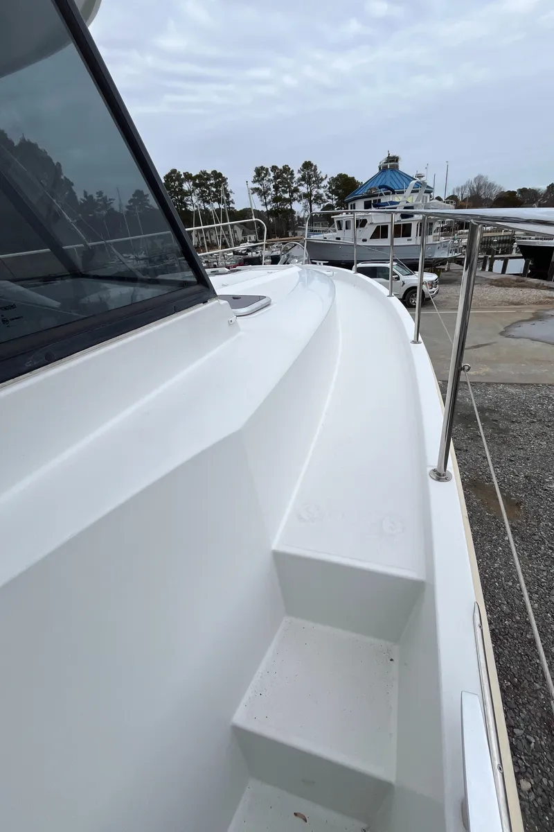 Slide: The Image of 2013 Beneteau Swift Trawler 34 docked, showcasing sleek deck design and marina background. - 23