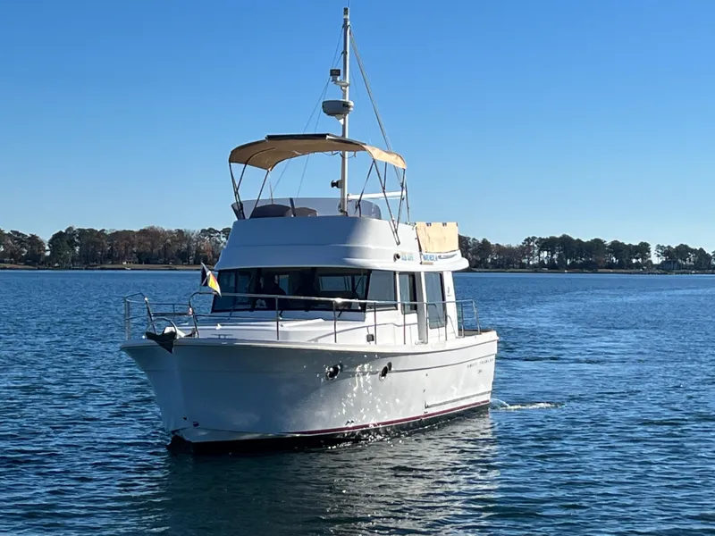 Slide: The Image of 2013 Beneteau Swift Trawler 34 cruising on calm waters under a clear blue sky. - 3