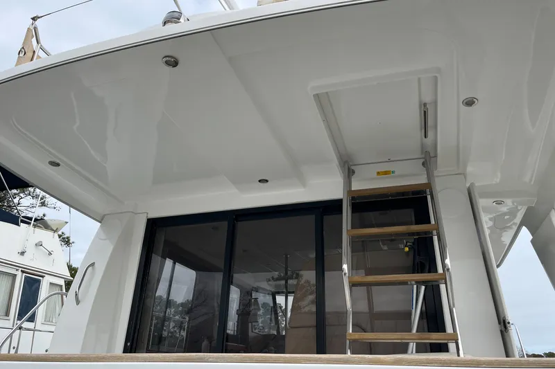 Slide: The Image of 2013 Beneteau Swift Trawler 34, rear view with ladder and glass doors. - 32