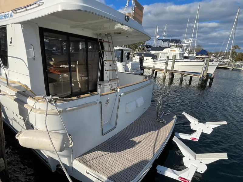 Slide: The Image of 2013 Beneteau Swift Trawler 34 docked at marina, rear view with open deck. - 4