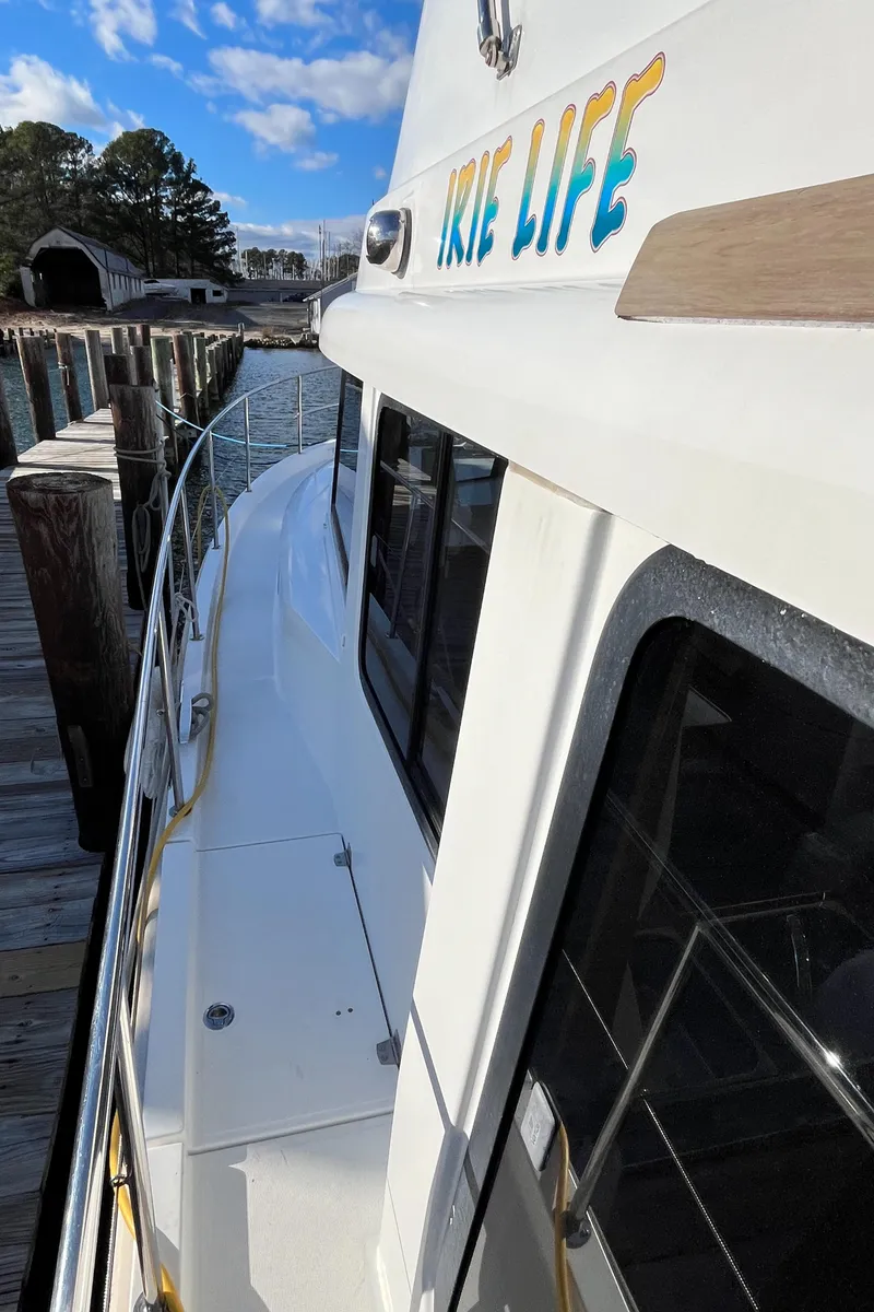 Slide: The Image of 2013 Beneteau Swift Trawler 34 docked, showcasing sleek design and "Irie Life" lettering. - 9