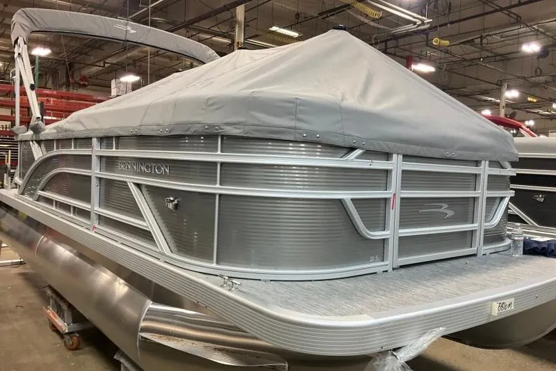 Slide: The Image of 2026 Bennington 20 SLSF pontoon boat with cover in a warehouse setting. - 16