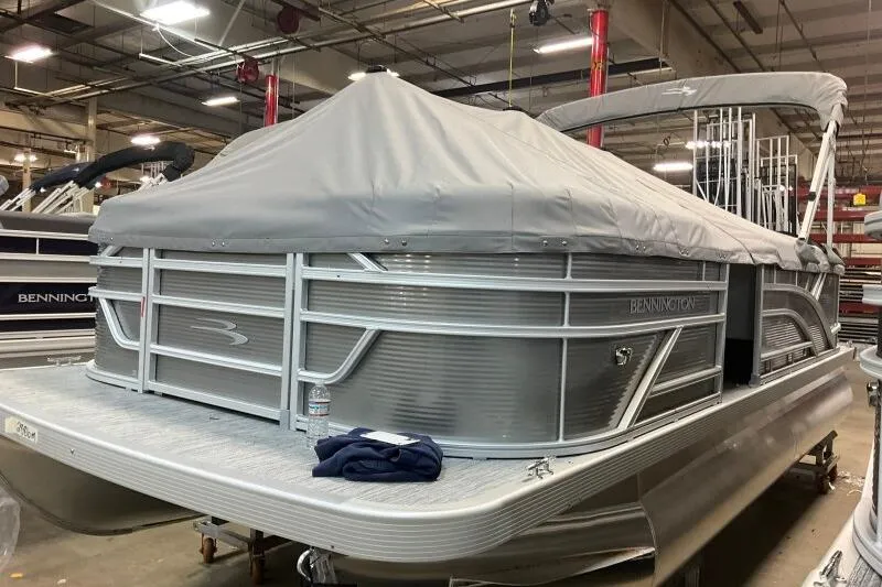 Slide: The Image of 2026 Bennington 20 SLSF pontoon boat with cover in a warehouse setting. - 17