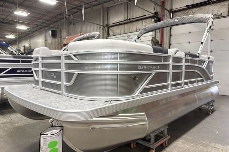 Slide: The Image of 2026 Bennington 20 SLSF pontoon boat in a showroom, featuring sleek silver design. - 4