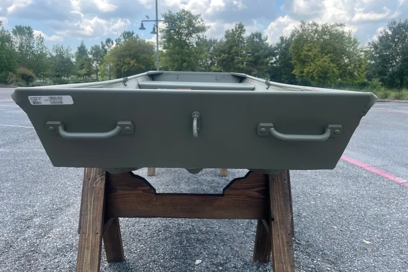 Slide: The Image of 2026 Tracker Grizzly 12 Jon boat on wooden stand, outdoor setting, cloudy sky. - 4