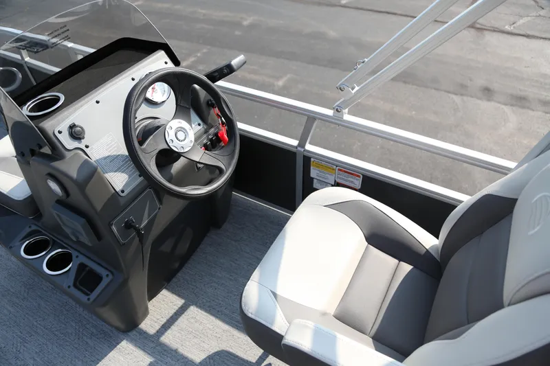 Slide: The Image of 2026 Sun Tracker Bass Buggy 16 XL Select boat interior with steering wheel and seating. - 3