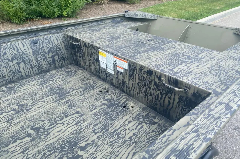 Slide: The Image of 2026 Tracker Grizzly 1648 Utility boat with camouflage pattern, parked outdoors. - 3
