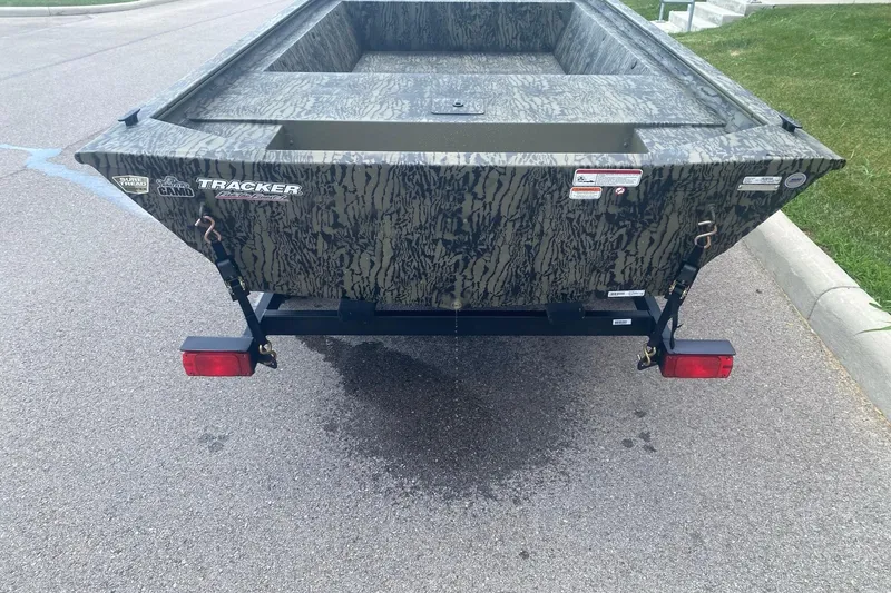 Slide: The Image of 2026 Tracker Grizzly 1648 Utility boat with camouflage design on a trailer. - 4