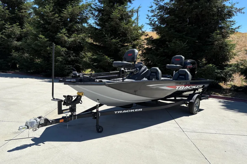 Slide: The Image of 2026 Tracker Pro Team 190 boat on trailer, parked outdoors with trees in background. - 6